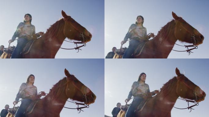 在晴朗明亮的日子里，一位年轻的美国原住民（纳瓦霍族）妇女骑着她的马，身后有一个小男孩