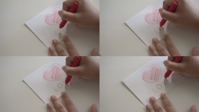 女人的手用蜡笔在白纸上写一个红色心形的爱