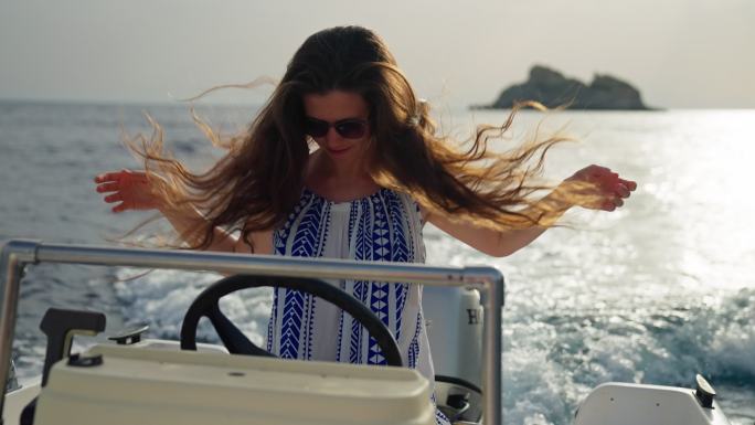 可爱而快乐的女孩驾驶快艇在梦中度假。乱抛头发