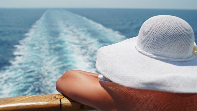 戴帽子的女人在游轮上欣赏风景