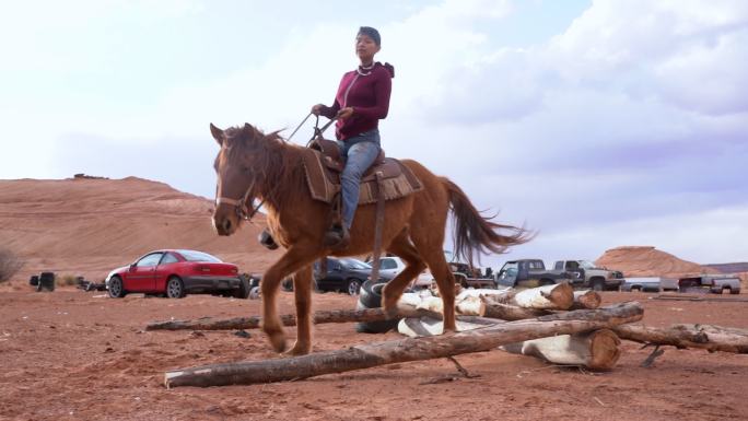 一个年轻的纳瓦霍女孩练习跳马越过临时障碍
