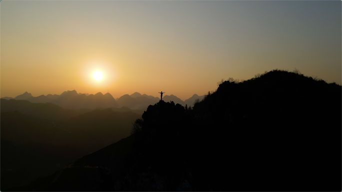 登山成功站在群山之巅张开双臂拥抱太阳天空