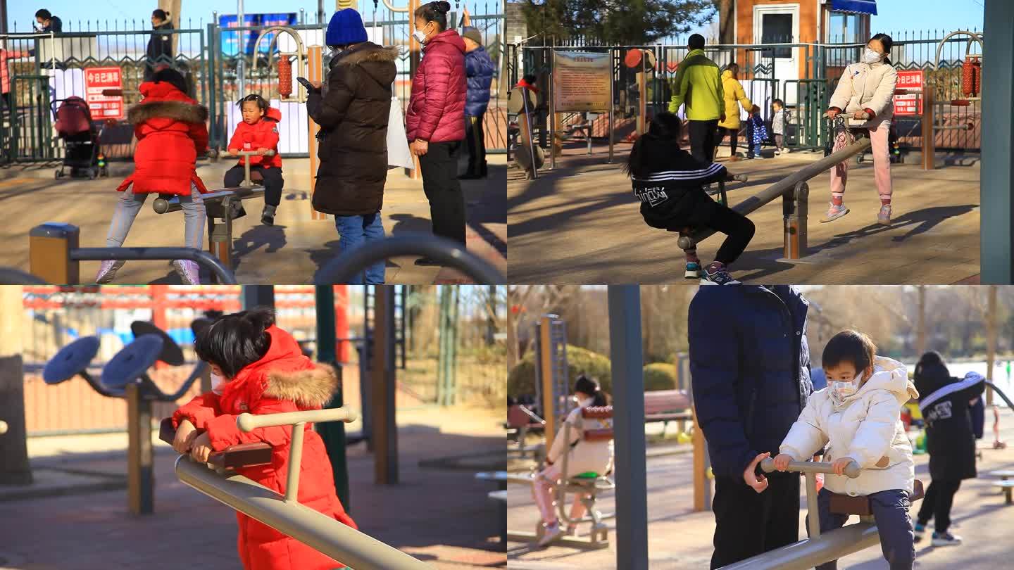 冬季公园健身场大人陪小孩玩跷跷板人文纪录