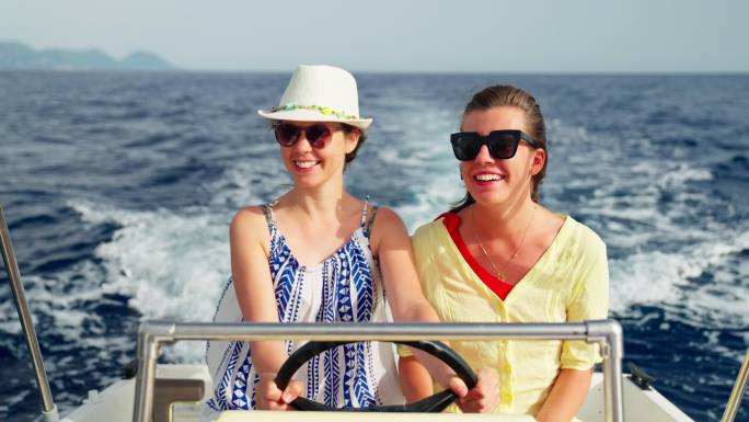 女性朋友在梦幻假期中享受快艇之旅。自然的微笑