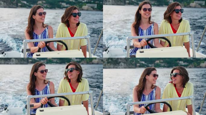 放松的女性朋友享受梦幻假期的快艇之旅。聊天和微笑拥抱