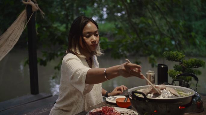 年轻的亚洲女人吃烧烤，不健康的饮食。