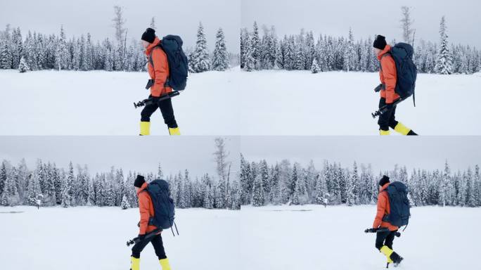 4K冬季冰天雪地中背着包行走的摄影师