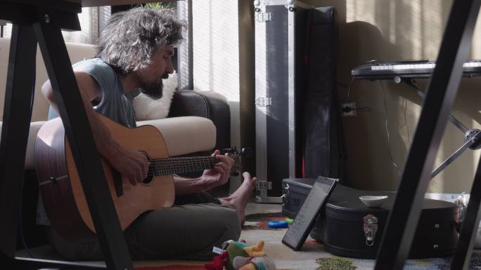 弹吉他的人，特写镜头。吉他手在家里重复演奏。