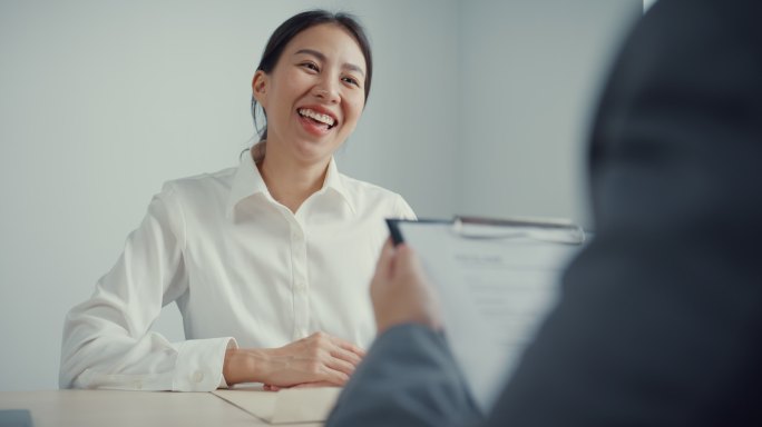 年轻的亚洲女商人在办公室讨论简历时面试。