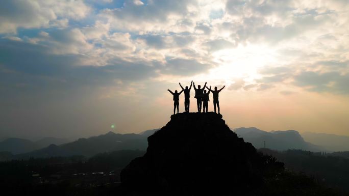 登山团队登山成功在山顶张开双臂庆祝胜利光