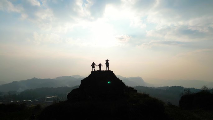 山顶一家四口幸福的一家四口登山逆光山顶看