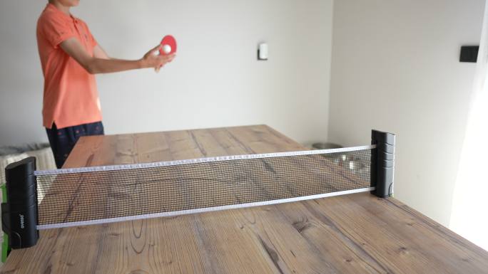 小男孩在家里室内打乒乓球。慢动作