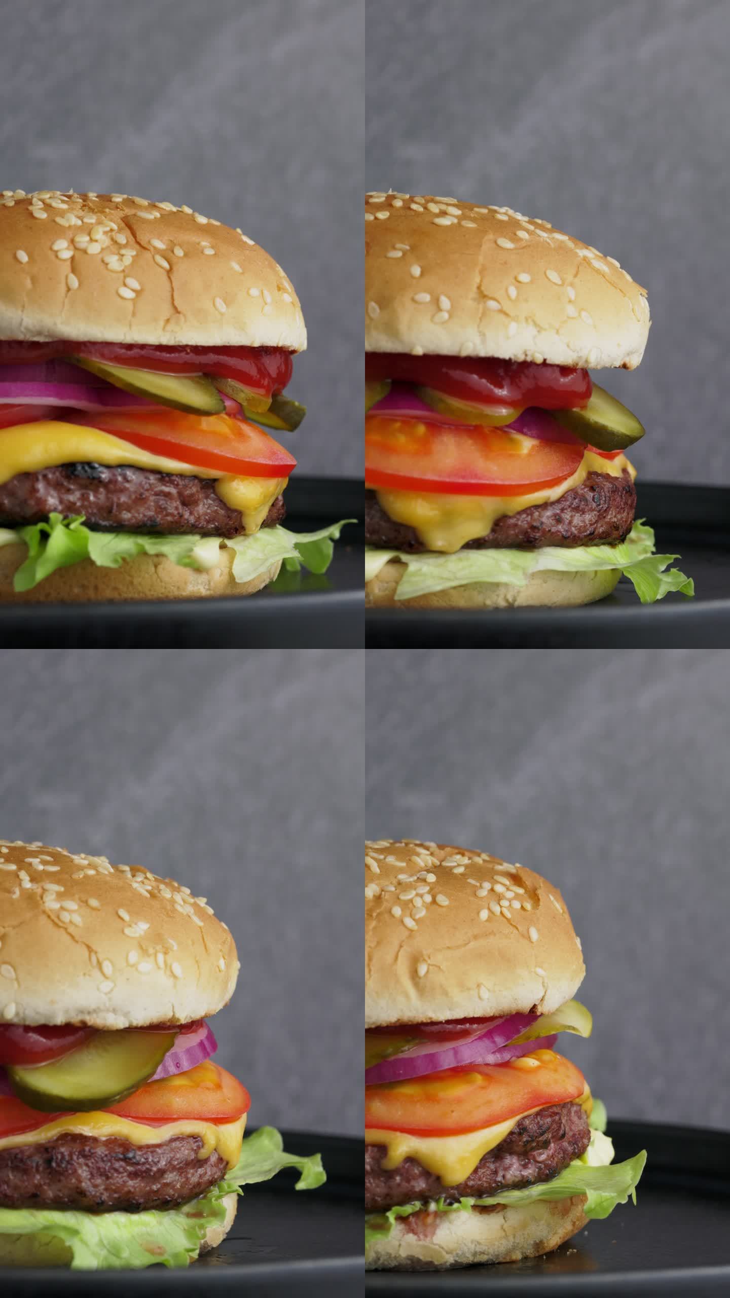 牛肉汉堡在黑色背景的黑色盘子上旋转360圈，特写。