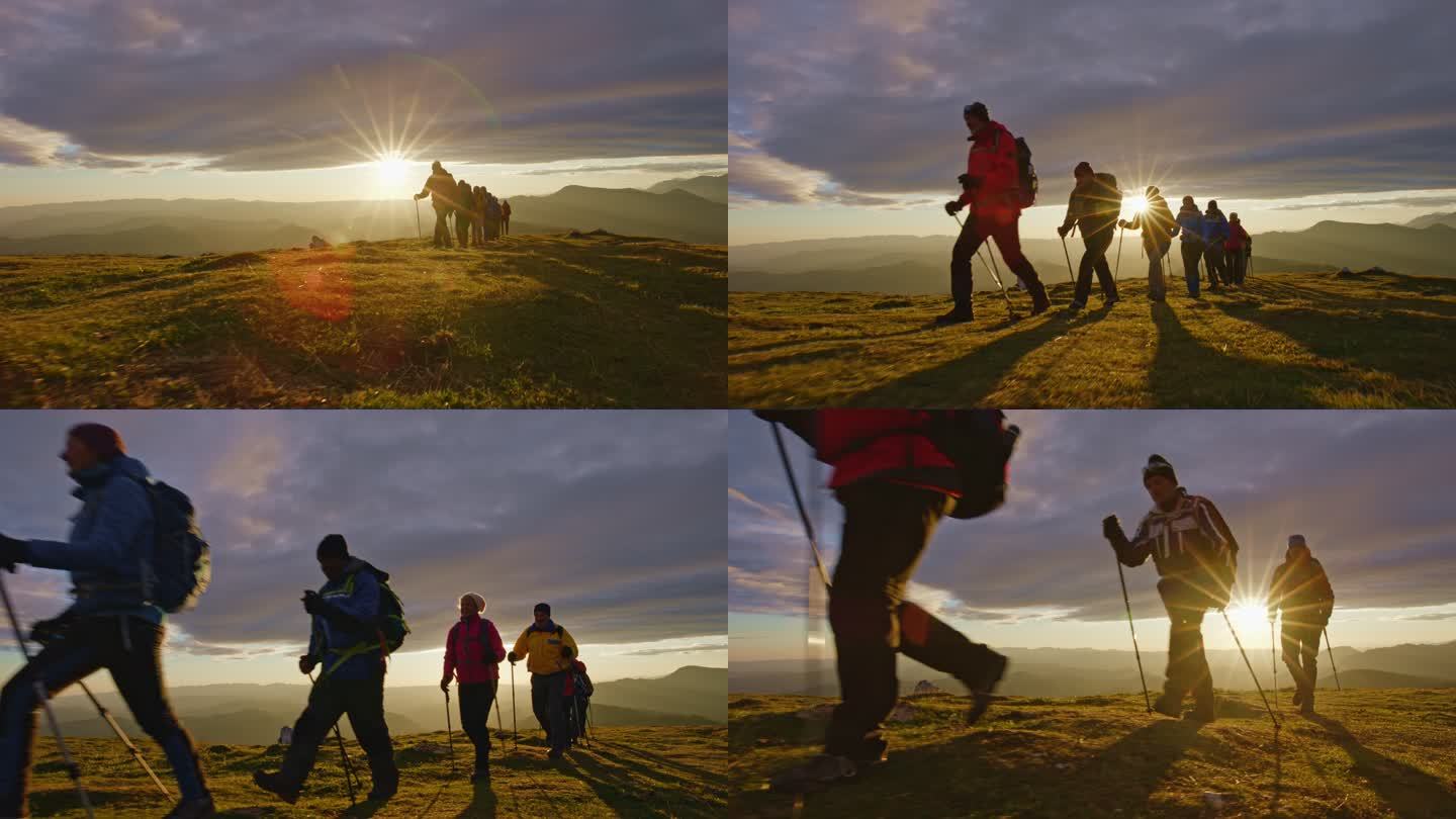 AERIAL SLO MO徒步旅行者在日落时在山顶上行走