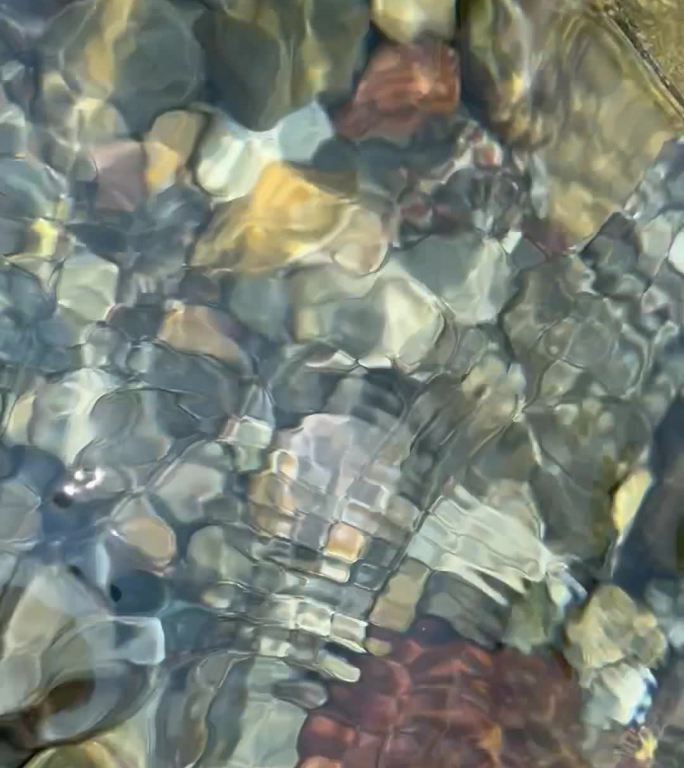 波光粼粼水面透出水下的石头