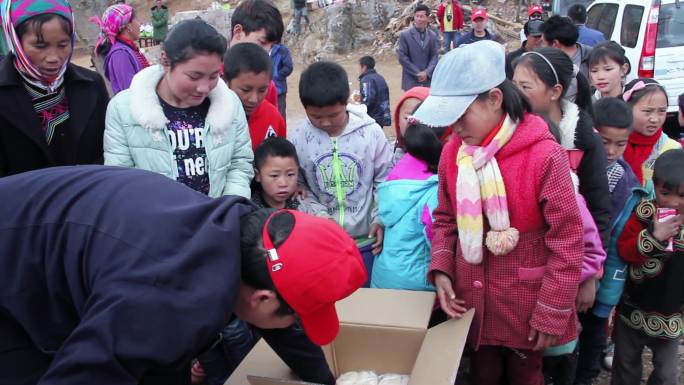 山区小学生排队领取捐赠学习用具