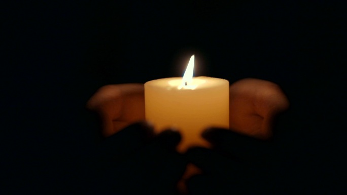 手拿着燃烧的蜡烛烛光烛火