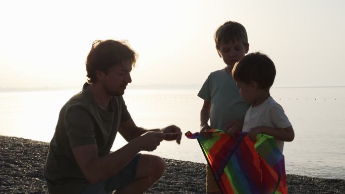 日落时分，年轻的父亲和儿子们一起在海边放风筝。父亲节