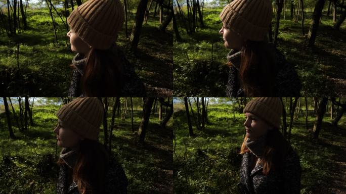 一个美丽的年轻女人在秋天的一天在森林里散步