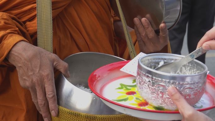 泰国一女子向佛教僧侣提供食物