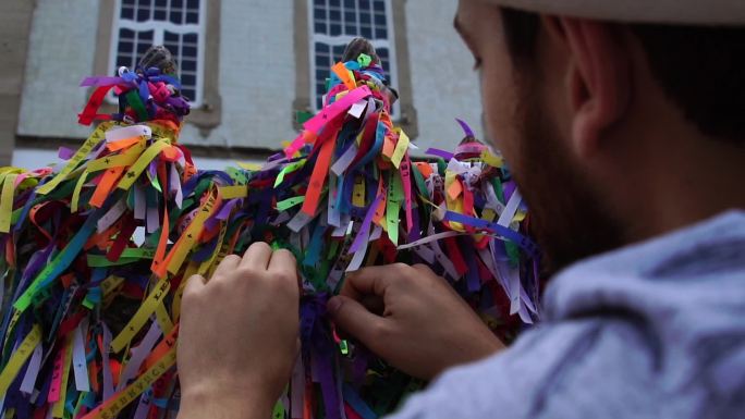 游客在巴伊亚萨尔瓦多的邦菲姆教堂上系丝带