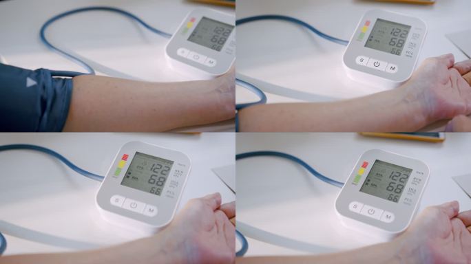 老年妇女在家中用医疗器械检查血压计和心率。