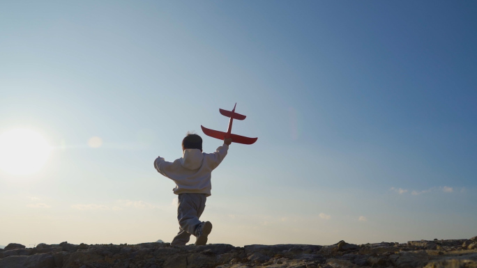 小男孩拿飞机模型山顶奔跑儿童节欢乐童年