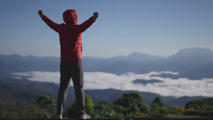 男子旅行者在山上放松并庆祝成功