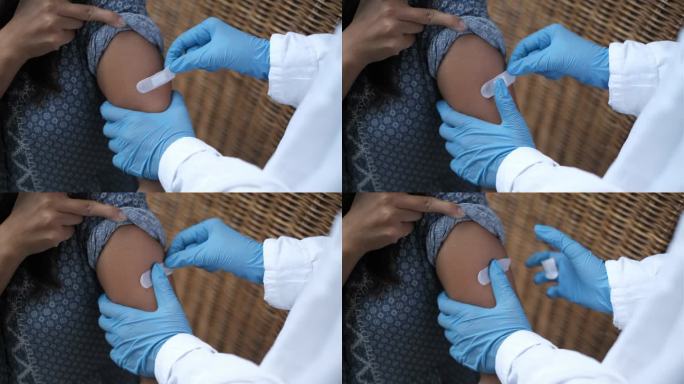 无法辨认的医生在接种新冠肺炎疫苗后给患者贴上胶带