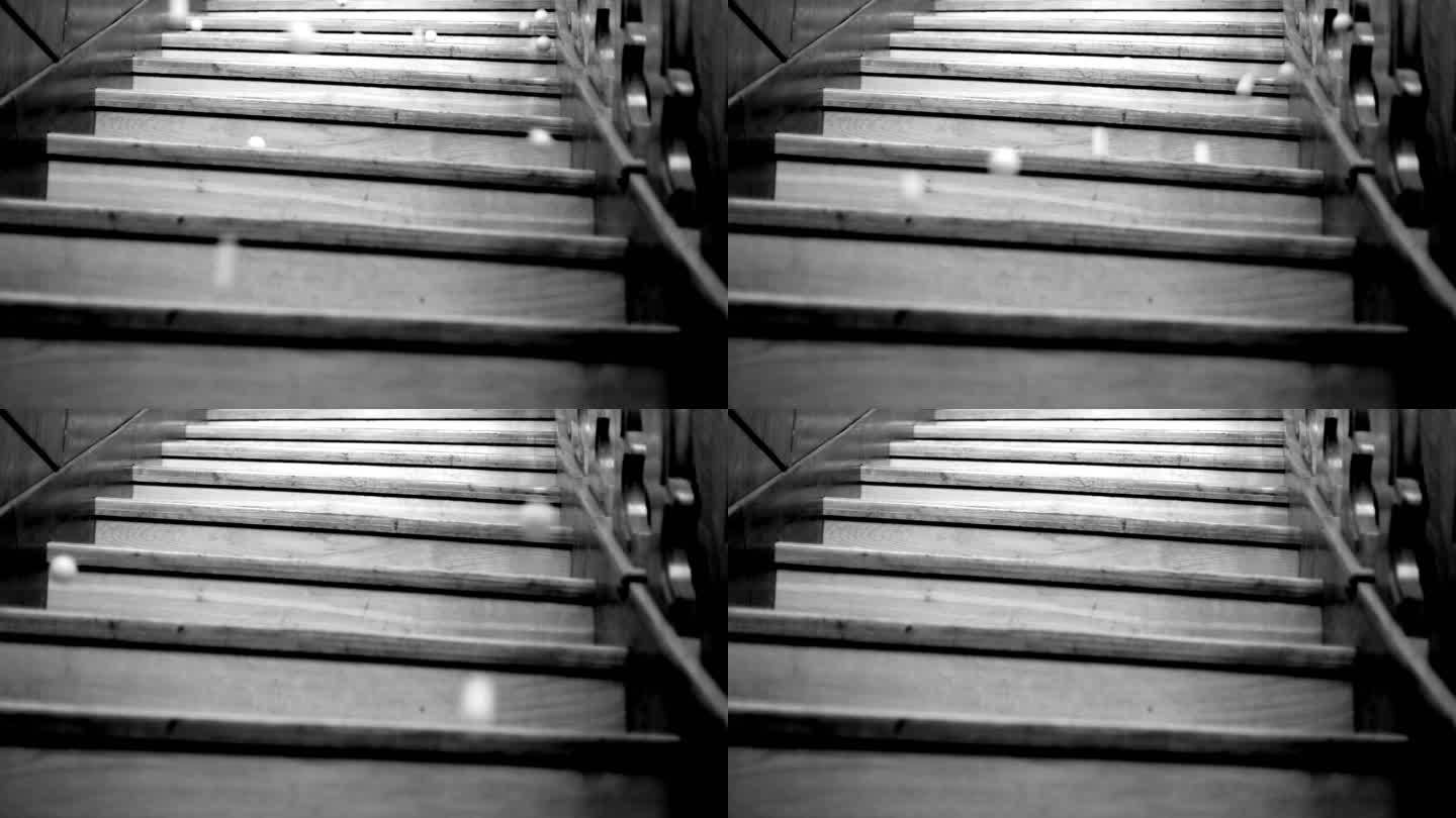 乒乓球从木制楼梯上落下，黑白相间
