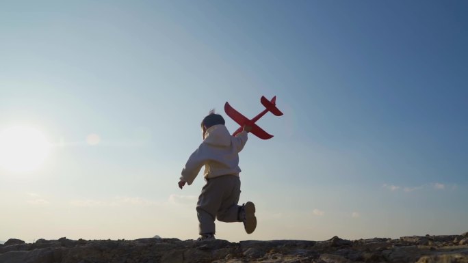 小男孩拿飞机模型山顶奔跑童年美好记忆梦想