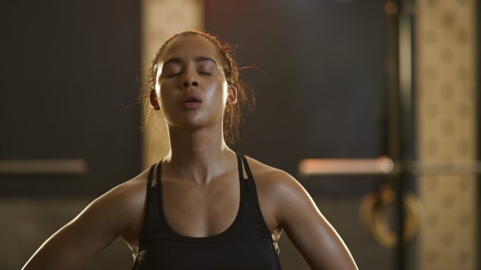 4k视频画面，一位年轻的运动女性在健身房锻炼时屏住呼吸