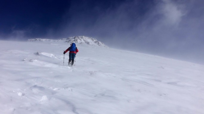 高姿态的暴风雪中的女登山者