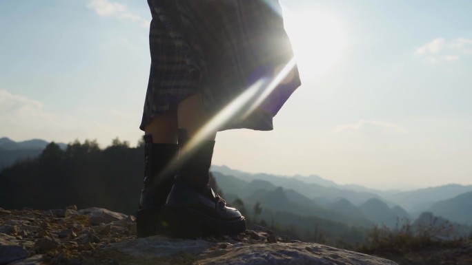 女生站在山顶逆光人物走向山顶眺望远方思考