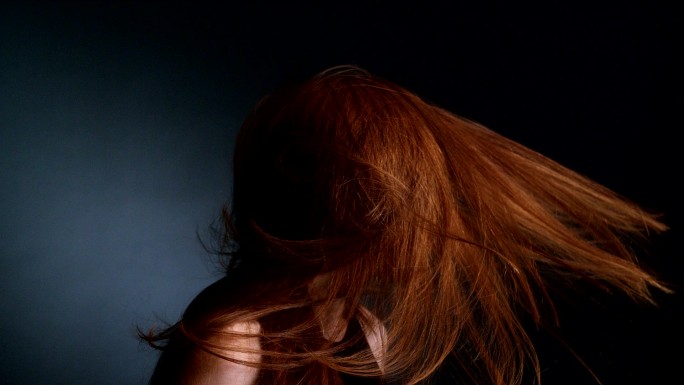 漂亮的红头发女孩撩着她的长发