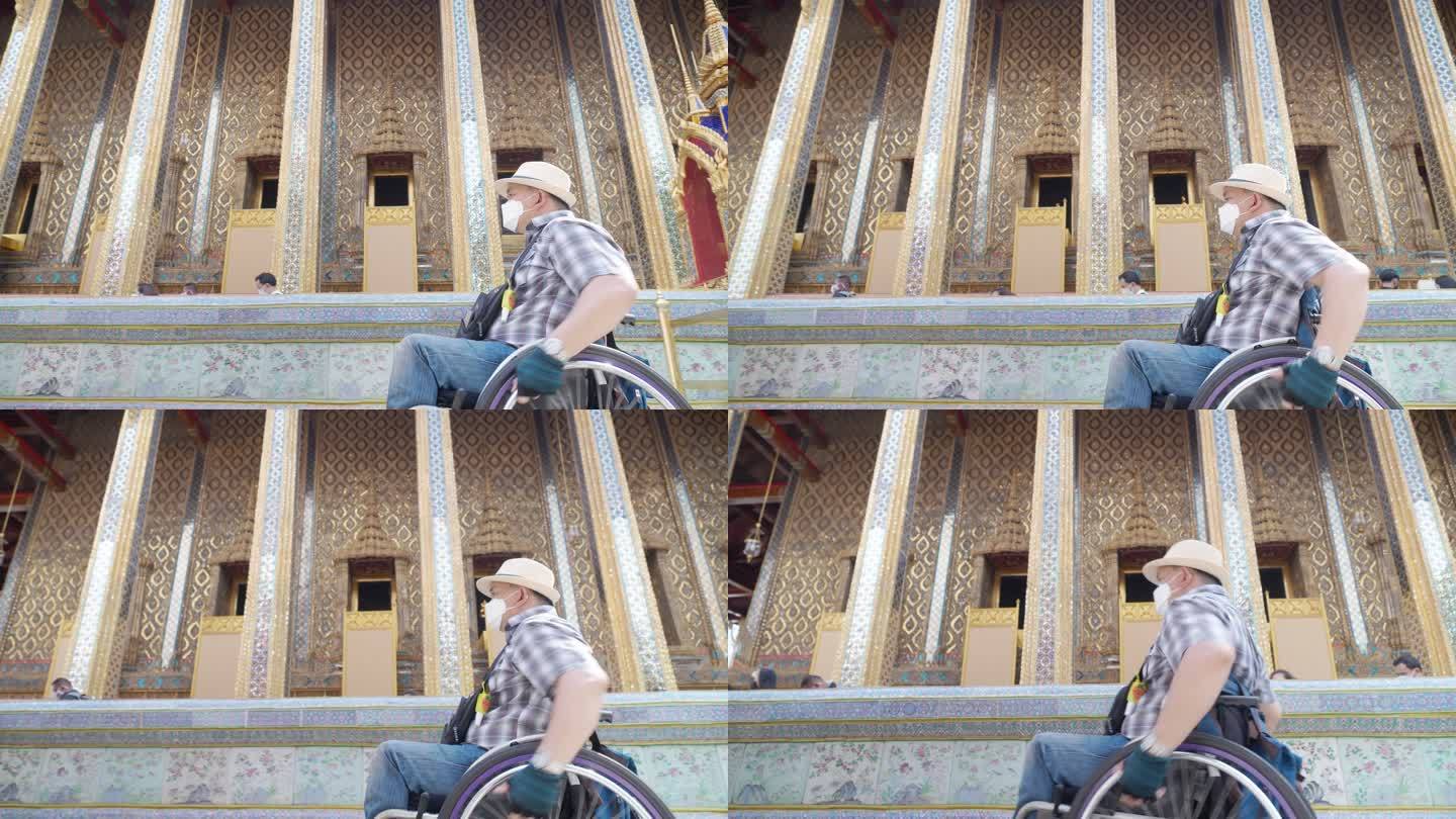 轮椅旅游地标曼谷概念。亚洲男性游客参观泰国曼谷湄南河大皇宫