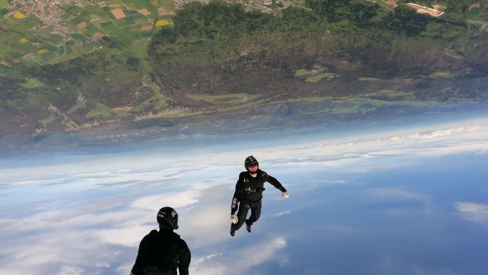 跳伞者在瑞士乡村景观上空翱翔