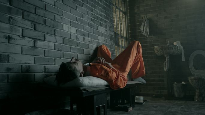 一名囚犯躺在牢房的床上
