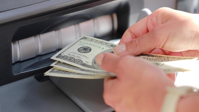 一位女士在ATM机取款时的手