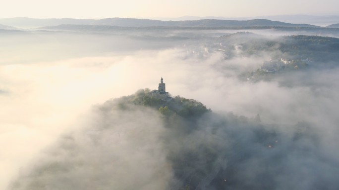 秋雾下日出时的可持续城市鸟瞰图。城市发展顺利，公园和自然空间众多。Veliko Tarnovo。