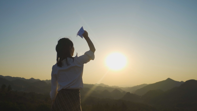 山顶扔纸飞机美女逆光背影放飞梦想渴望自由