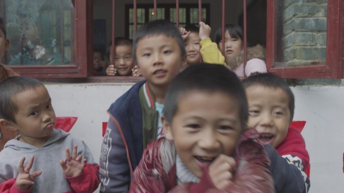 贫困山区小学留守儿童对着镜头微笑做鬼脸玩