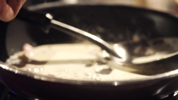 在厨房做饭时，手的慢动作会在平底锅中加入黑胡椒粉