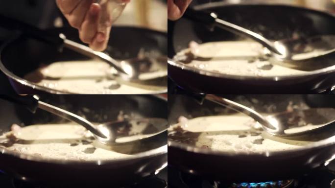 在厨房做饭时，手的慢动作会在平底锅中加入黑胡椒粉