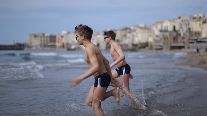 两个男孩喜欢跑步和跳海