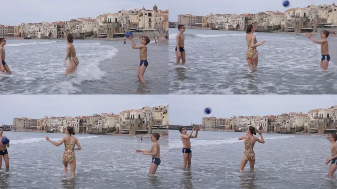 在西西里小镇的海滩上玩球的青少年