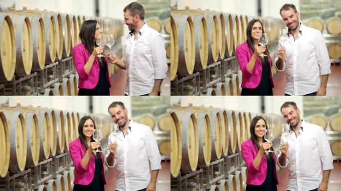 幸福的夫妇在葡萄酒窖里喝白葡萄酒