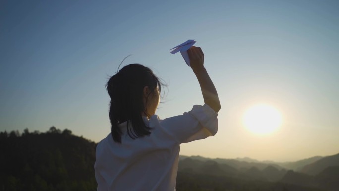 逆光女生背影扔纸飞机未来可期向往自由梦想