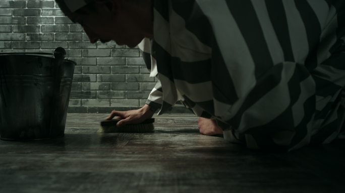 罪犯在惩教所牢房清洁地板