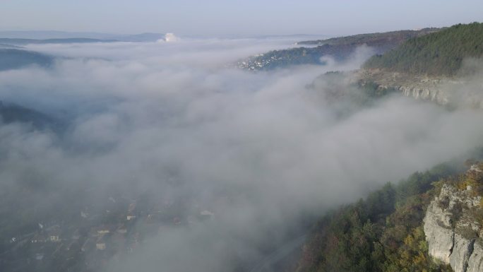 秋雾下日出时的可持续城市鸟瞰图。城市发展顺利，公园和自然空间众多。Veliko Tarnovo。